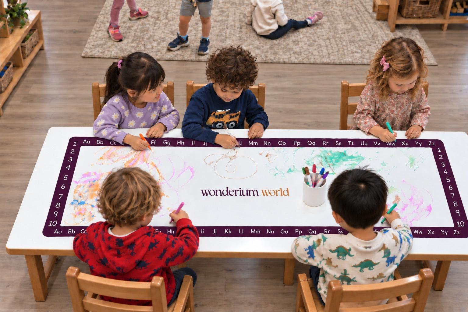 Children exploring a Wonderium learning mat together at an early childhood table